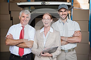 Warehouse managers and delivery driver smiling at camera