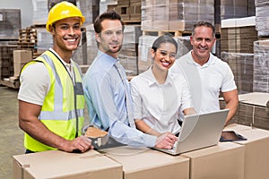 Warehouse managers and worker looking at camera