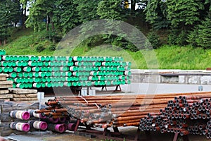 A warehouse of metal pipes of various sizes under the open sky. Technologies of construction industry. Transport of liquids under