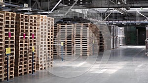 Warehouse with racks and shelves, filled with cardboard boxes, wrapped in foil on wooden pallets. Clip. Large and light