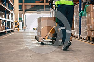 Warehouse staff moving load parcel box with Hand pallet truck or Hand lift manual delivery shipping goods in shelf storage area