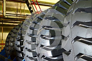 Warehouse with tires for trucks at an industrial plant for the production of cars. The protector of a large rubber wheel. Rubber