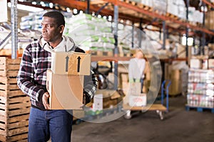 Warehouse worker carrying carton boxes