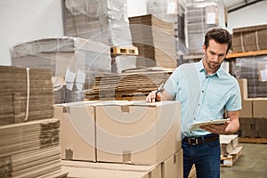 Warehouse worker checking his list on clipboard