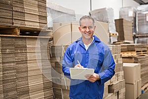 Warehouse worker checking his list on clipboard