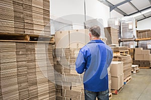 Warehouse worker checking his list on clipboard