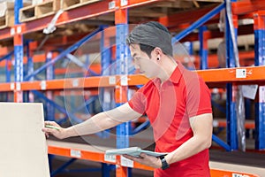 Warehouse worker checking inventory in warehouse, Forman worker working in factory warehouse photo