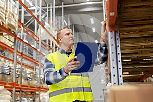 Warehouse worker with clipboard in safety vest