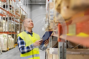Warehouse worker with clipboard in safety vest
