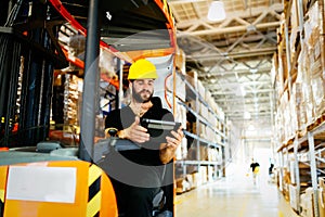 Warehouse worker doing logistics work with forklift loader