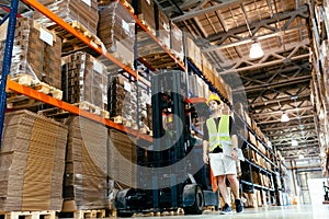 Warehouse worker doing logistics work with forklift loader