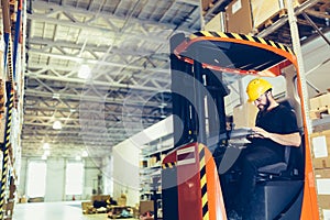 Warehouse worker doing logistics work with forklift loader