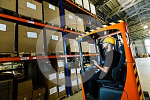 Warehouse worker doing logistics work with forklift loader