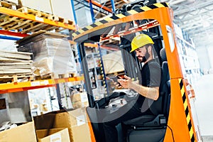 Warehouse worker doing logistics work with forklift loader