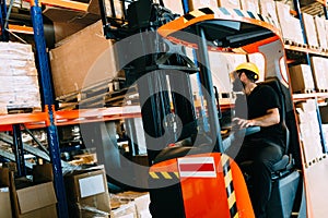 Warehouse worker doing logistics work with forklift loader