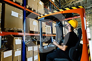 Warehouse worker doing logistics work with forklift loader
