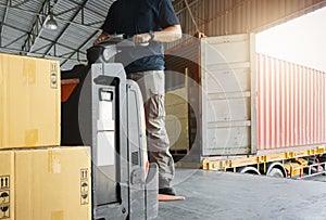 Warehouse worker driving forklift pallet jack unloading shipment goods. Warehouse and Road frieght truck transportation.