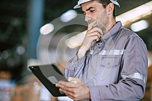 Warehouse worker, Engineer manager looking at tablet screen with thinking have a problem expression