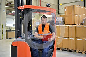 warehouse worker in a forwarding agency - interior with forklift - transport and storage of goods