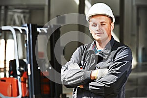 Warehouse worker in front of forklift