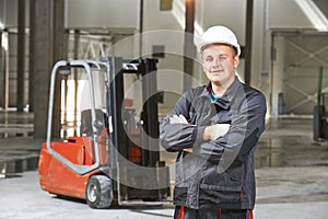 Warehouse worker in front of forklift