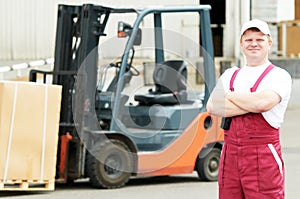 Warehouse worker in front of forklift