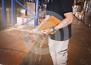 Warehouse worker holding clipboard checking order. inventory management of product. warehousing storage. checking stock.
