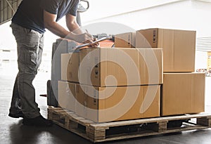 Warehouse worker holding clipboard his doing inventory management cargo boxes. Checking stock. Shipment boxes. Warehousing storage