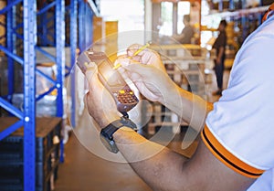 Warehouse Worker Holding Mobile Phone Contacting to a Customer. Cargo Shipment Supply Chain. Inventory Management at Storage. photo