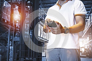 Warehouse Worker Holding Mobile Phone Contacting to a Customer. Shipment. Inventory Management at Storage Warehouse. Supply Chain.