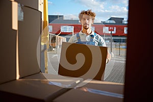 Warehouse worker loading van preparing parcel box for delivery