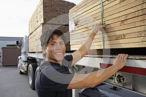Warehouse Worker Loading Wooden Planks On Truck Carrier