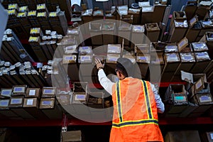 Warehouse worker looking for the right box on the shelf.