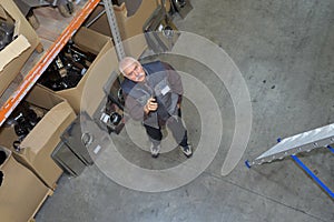 Warehouse worker looking up into racking