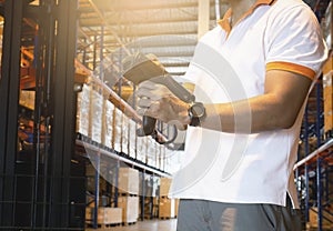 Warehouse worker pushing buttons on barcode scanner. Computer equipment for warehouse inventory management.