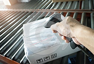 Warehouse Worker Scanning Bar Code Scanner on Package Boxes.