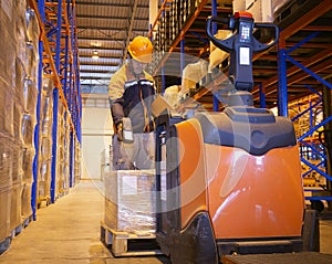 Warehouse worker scanning bar code scanner with shipment goods pallet.