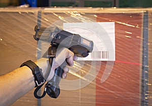Warehouse worker  scanning barcode scanner on label of shipment product. Computer equipment for warehouse inventory management