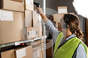 warehouse worker scans a barcode on a box in a large warehouse. brazilian woman worker scans package with barcode