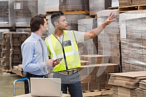 Warehouse worker showing something to his manager