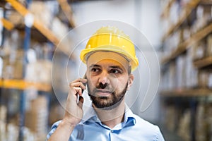 Warehouse worker or supervisor with a smartphone.