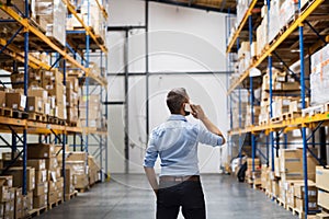 Warehouse worker or supervisor with a smartphone.