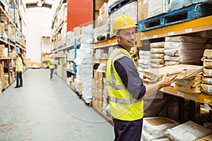 Warehouse worker taking package in the shelf