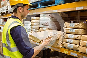 Warehouse worker taking package in the shelf