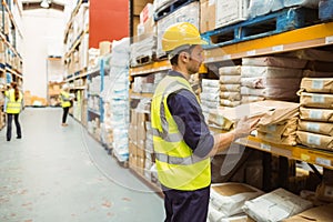 Warehouse worker taking package in the shelf