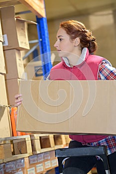 Warehouse worker taking package in shelf in warehouse