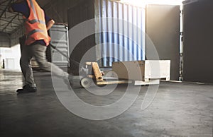 Warehouse Worker Unloading Package Box Out of The Inside Cargo Container. Truck Parked Loading at Dock Warehouse. Delivery Service