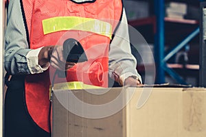 Warehouse worker using barcode scanner in storehouse