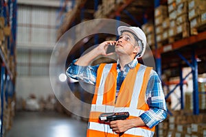 Warehouse worker using a phone holding barcode reader working in a distribution center