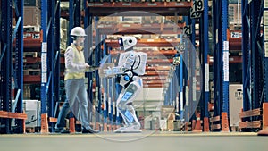 Warehouse worker working with delivery robot